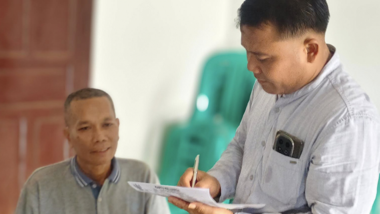 Pak Kades Rahmat Turun Langsung Membantu Warga dalam Antrian Pembuatan BPJS Kesehatan di Desa Sidomulyo