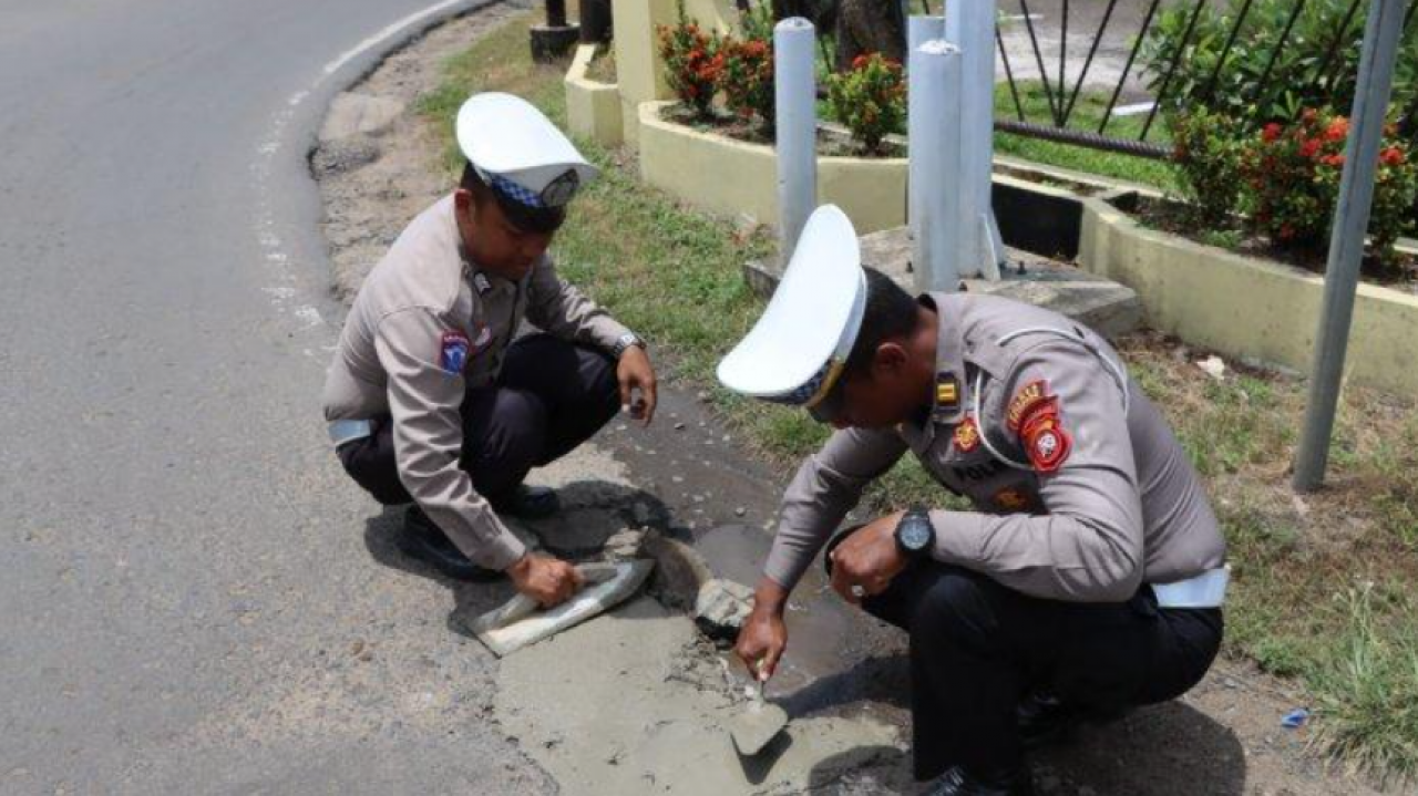 Polisi Polres Ketapang Bersama Warga Bergotong Royong Lakukan Penambalan Jalan Berlubang